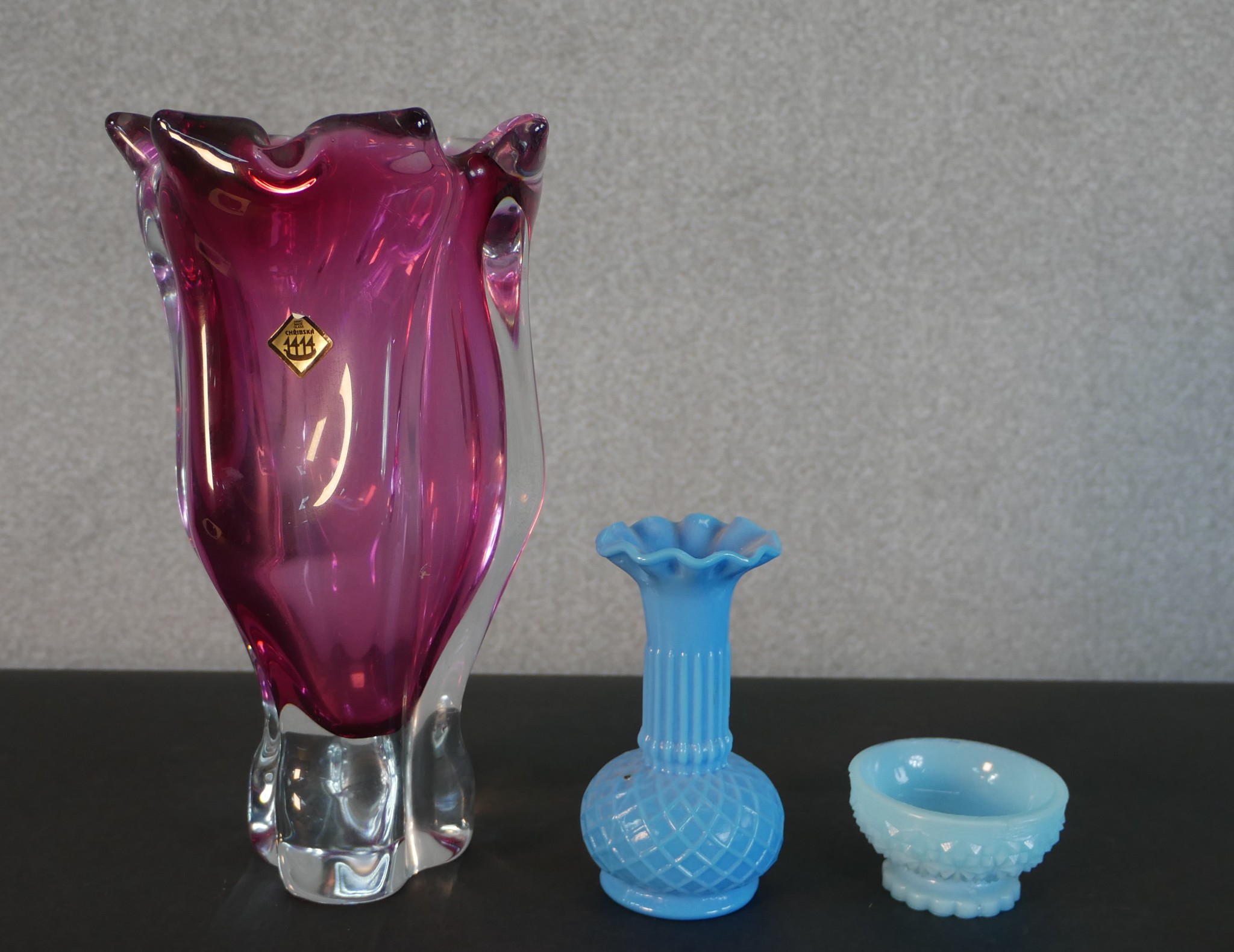 A large Chribska Czech studio cranberry glass vase along with two pressed opaline blue glass pieces.