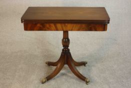 A George III style mahogany card table, the foldover top with a green baize lining on a quatraform