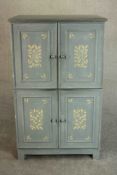 A late 20th century blue/grey painted cupboard with two cupboard doors, leaf design over another