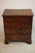 A George III mahogany bachelors chest of four long graduated drawers with brass swing handles on