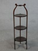 An early 20th century walnut folding cake stand, with three circular dished tiers. H.90cm