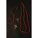 A collection of early 20th century Oriental red coral jewellery. A three strand Chinese coral
