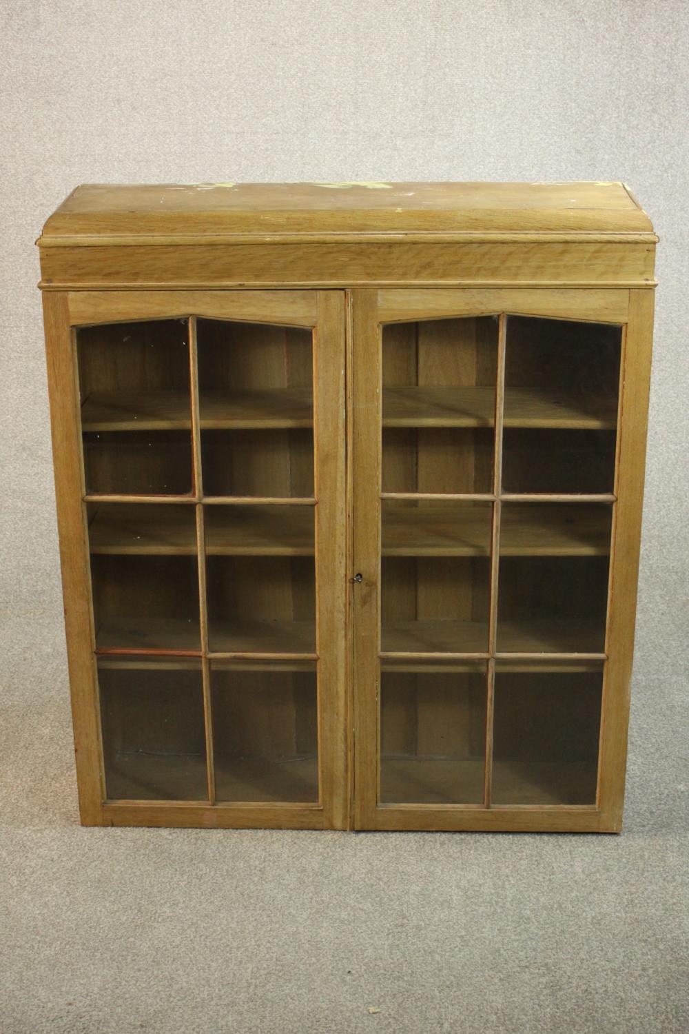 A 20th century oak bookcase section, with two glazed doors enclosing three shelves. H.102 W.92 D.