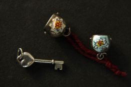 Two miniature vintage sterling silver Swiss cowbell charms with enamel detailing along with a