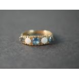 A 9 carat gold blue topaz and opal five stone ring, set with two round cabochon opals with a