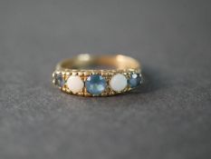 A 9 carat gold blue topaz and opal five stone ring, set with two round cabochon opals with a