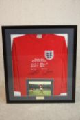 A framed and glazed Geoff Hurst and Martin Peters signed England football shirt to commemorate the