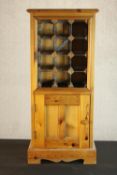 A late 20th century pine wine rack cabinet, with space for twelve bottles of wine over a single