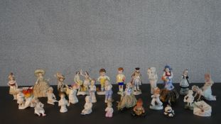 A collection of twenty five 19th and 20th century porcelain and ceramic figures, many of children or