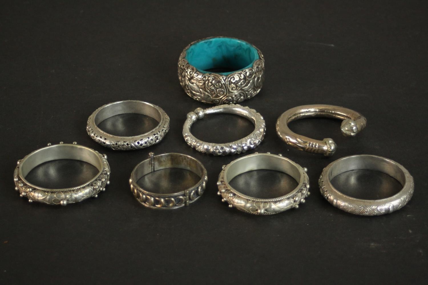 A collection of five white metal Oriental bangles and three silver plated bangles. A pair of Chinese