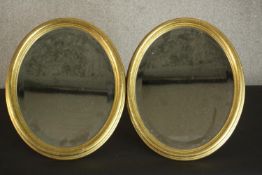 A pair of late 20th century oval mirrors with a bevelled mirror plate in a gilt frame. H.38 W.31cm