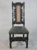 A 17th century style oak high back side chair with a caned and carved back over a velour upholstered