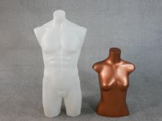 A contemporary male torso mannequin in white, together with a copper coloured female mannequin