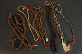 A collection of six 20th century malas made from various materials; seeds, agate and two with silver