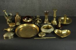 A collection of brass items, including a pestle and mortar, candlesticks and chambersticks, a