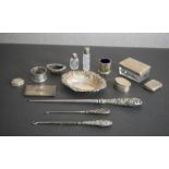 A collection of assorted silver items, including three boot hooks, a repousse design silver dish,