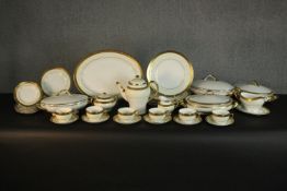 A Minton Buckingham pattern bone china dinner service, with gilt borders and handles, comprising