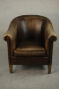 A contemporary brown leather tub chair, with studded detail to the arms on square section tapering
