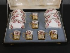 A leather cased Crown Staffordshire fine china six person coffee set with pierced gilt metal cup