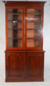 A late Victorian walnut bookcase with a pair of glazed doors enclosing adjustable shelves over a