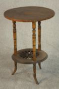 A circular walnut occasional table, the top inlaid with a patera, on turned legs joined by a pierced