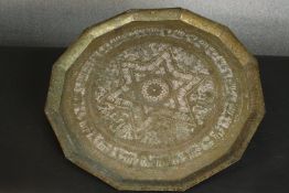 A Middle Eastern brass tray of dodecagon shape, with chased designs centered by a star. Dia.58cm.