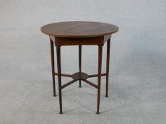 An Edwardian Arts & Crafts mahogany circular occasional table with five tapering legs with pad
