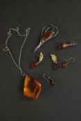 A collection of amber jewellery, including a large amber chunk pendant on chain, a pair of amber and