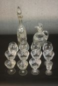 A collection of twelve crystal and glass drinking glasses along with an etched vine design