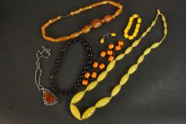 A collection of amber and faux amber jewellery, including a cherry amber graduated bead necklace,