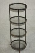 A four tier wrought iron stand, possibly a saucepan stand, each circular tier lined with mesh. H.