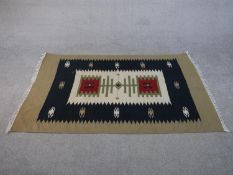 A hand woven Turkish Kelim with geometric serrated pendants on a biscuit ground. L.176 W.115cm