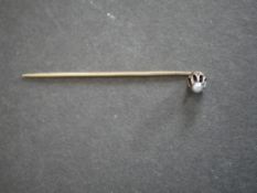 A yellow metal and cultured pearl stick pin in an antique leather box.