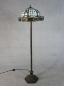 A Tiffany style standard lamp, with a stained glass shade, on a bronzed metal stem with a