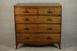 An early 19th century mahogany chest of two short over three long drawers with knob handles, above a