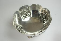 A scalloped edge floral repousse design bowl on shaped foot. H.7 Dia.13cm. Weight 146gm.