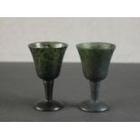 A pair of Chinese spinach jade miniature goblets with bell shaped bowls, tapered stems and domed