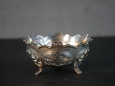 A silver pierced design scalloped edged bowl on three engraved feet. Stamped Silver. 132g