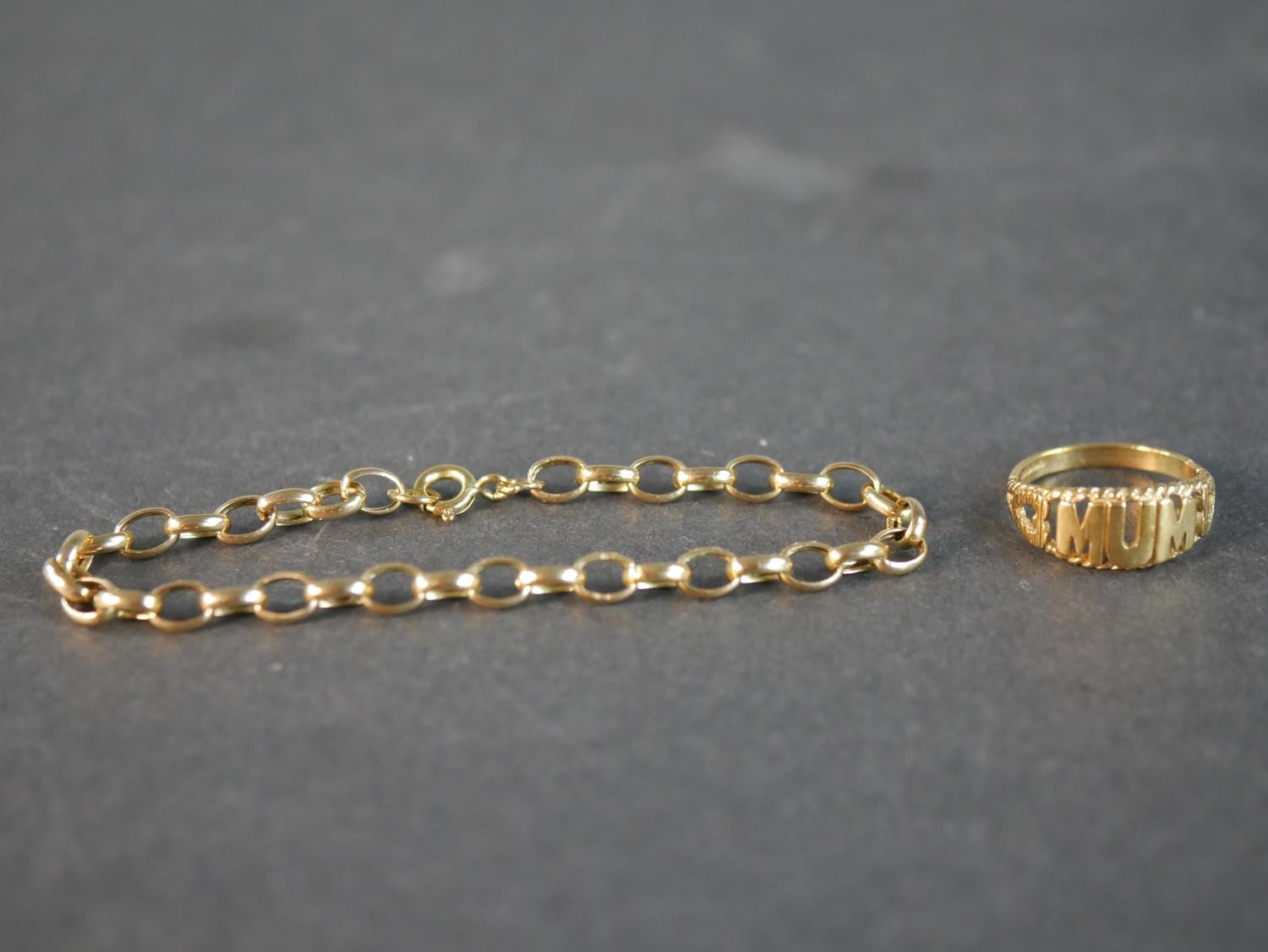A 9ct yellow gold MUM ring along with a 9ct yellow gold oval link bracelet. Ring size 1/2. 4.23g