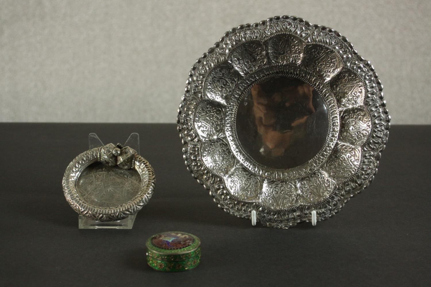 Three Oriental silver and white metal pieces, including a repousse design floral form dish on