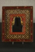 An Indian carved, red painted and parcel gilt mirror, the small mirror plate surrounded by pierced
