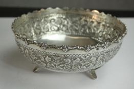 A silver repousse scrolling floral and foliate design bowl on three feet. Stamped Silver. H.8 Dia.