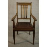 A circa 1900 hardwood open armchair, with a brown leather drop in seat, on square section tapering