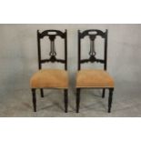 A pair of late Victorian walnut dining chairs, with pierced splat backs over yellow upholstered