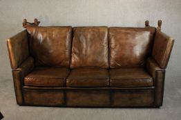 A Knole style contemporary brown leather sofa, with turned stained beech finials and studded
