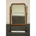 A George II style walnut swing frame toilet mirror, in a moulded frame with a reeded stand. H.62 W.