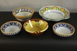 A collection of five hand painted Continental majolica ceramic glazed bowls, some painted with fruit