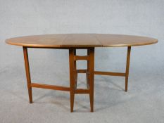 A late 20th century teak drop leaf dining table, the top of oval form with gateleg supports. H.74