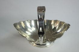 A gadrooned silver basket with handle. The handle with a pierced geometric design. Stamped silver.