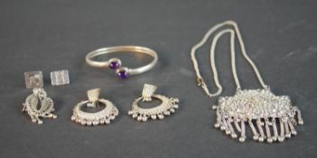 A collection of silver and white metal jewellery, including an amethyst cabochon bangle, an Indian
